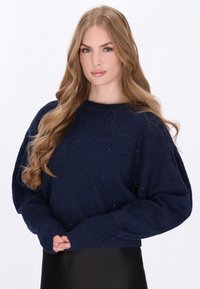 Marineblauwe trui van gestructureerde breiwerkstof, met een losse pasvorm, brede mouwen en subtiele glinsterende accenten overal.