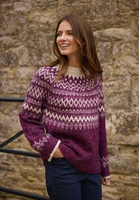 Strickpullover in tiefem Lila mit geometrischen Mustern in Weiß. Verfügt über einen runden Halsausschnitt und gerippte Bündchen an den Ärmeln.