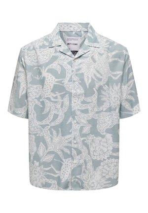 Camisa de manga corta azul claro con patrones florales y de animales en blanco, con cierre de botones en la parte delantera y un diseño de cuello estándar. Textura de tela ligera.