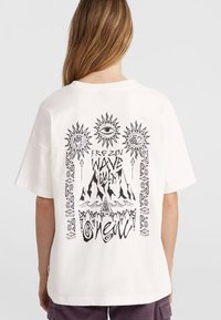 Witte katoenen T-shirt met een zwart grafisch ontwerp van de zon, bergen en tekstmotieven. Zachte textuur, relaxte pasvorm, korte mouwen.