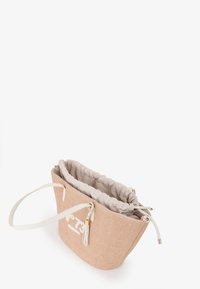Borsa in tessuto intrecciato beige con chiusura a coulisse e interno beige chiaro. Presenta un logo bianco e un dettaglio decorativo con pon-pon.
