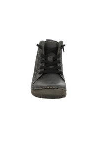 Zapato de cuero negro con punta redonda, con cordones negros, costuras en contraste y una superficie texturizada. Suela de goma de perfil bajo.