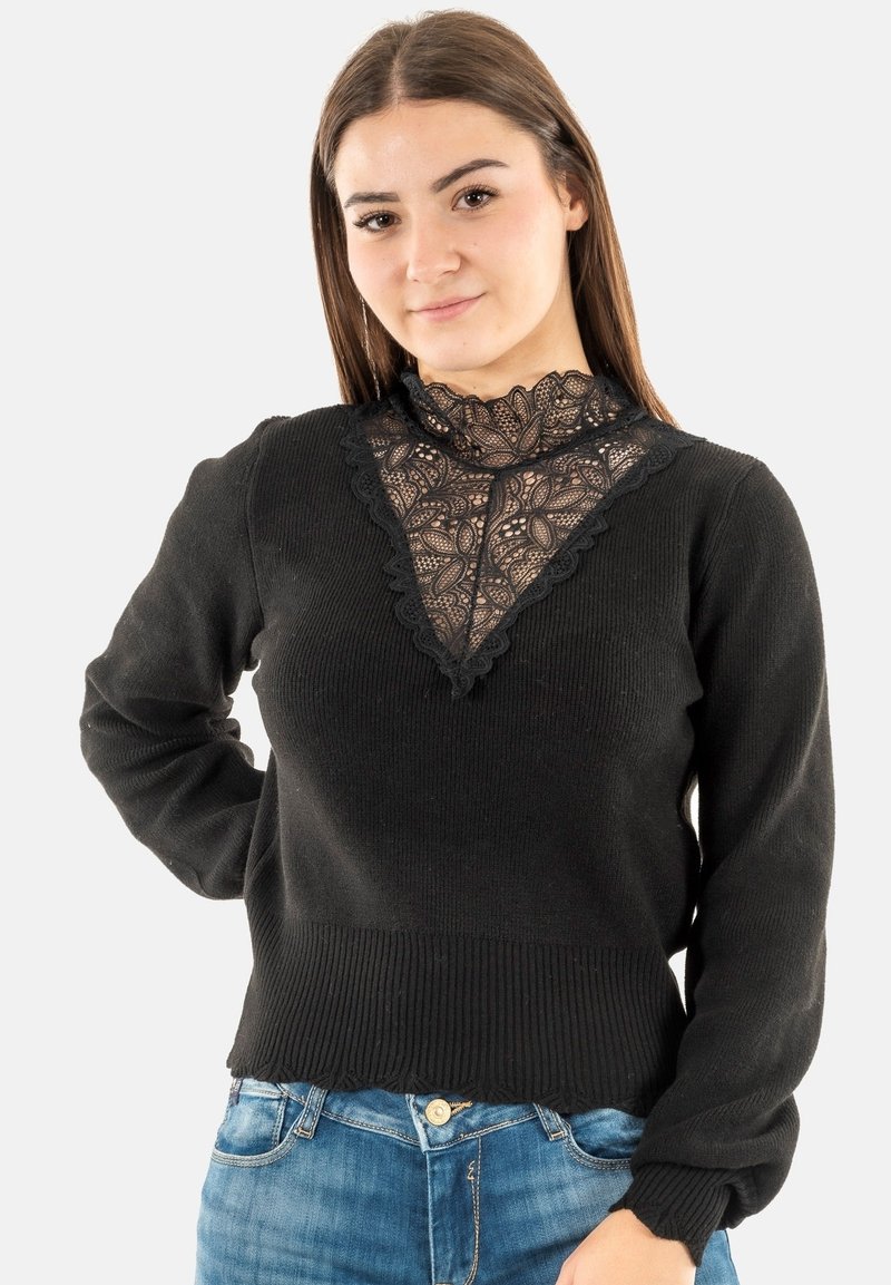 Črn pulover s čipkastim poudarjenjem ob vratu, rebrasto teksturo na robovih in manšetah ter oprijetim dizajnom. V kombinaciji z modrimi jeans hlačami.