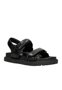 Sandali in pelle nera con suola piatta, ampie cinghie, schienale regolabile con fibbia e dettagli texturizzati. Adatti per un look casual.