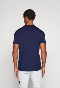 Camiseta de manga corta azul marino en una suave tela texturizada. Presenta un escote de cuello redondo y un dobladillo recto, adecuada para el uso casual.