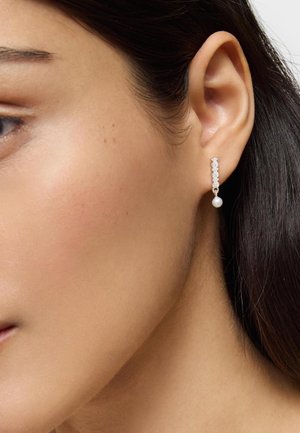 Orecchini d'argento con un design lineare caratterizzato da piccoli accenti circolari e una singola goccia di perla. Il metallo presenta una finitura lucida.