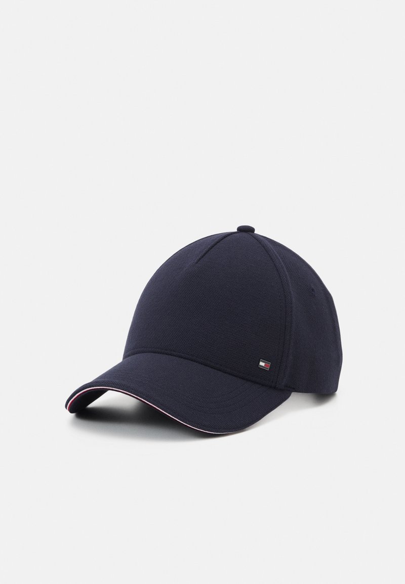 Casquette de baseball bleu marine avec une visière incurvée, un petit logo sur le côté, et un délicat liseré rouge et blanc le long du bord de la visière.