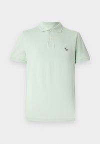 Light green polo shirt made of cotton, featuring a buttoned placket, short sleeves, and a small embroidered logo on the left chest.