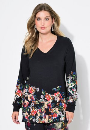 Haut noir à manches longues en V avec un motif floral coloré le long de l'ourlet et des manches, fabriqué à partir d'un tissu doux et extensible.