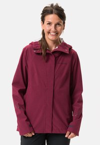 Giacca impermeabile bordeaux con cappuccio, dotata di zip frontale a lunghezza completa, dettagli riflettenti e polsini regolabili. Texture del tessuto liscia.