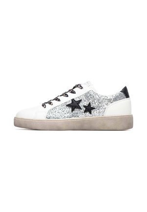 Zapatilla blanca con detalles de purpurina plateada y diseños de estrellas negras. Cuenta con cordones negros y una suela gris texturizada. Material de cuero liso.