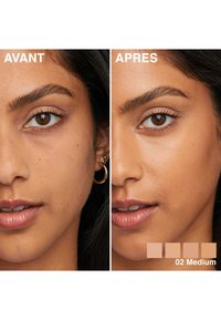 Photos avant-après montrant une peau moyenne avec des imperfections visibles à gauche, un teint lisse et uniformément toné à droite. Une petite boucle d'oreille en argent est visible.