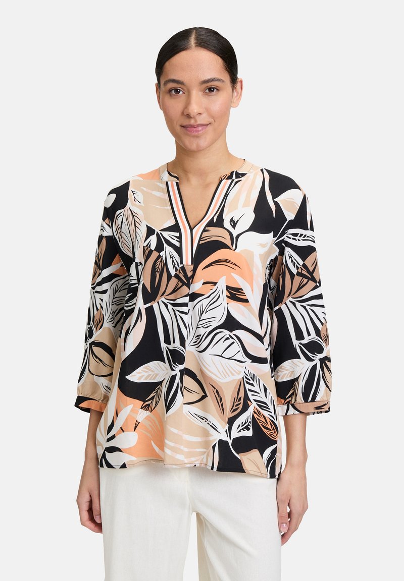 Kwiatowa bluzka w czarnych, beżowych i brzoskwiniowych odcieniach z rękawami do trzech czwartych, dekoltem w serek i luźnym krojem. Posiada wyraziste wzory liści.