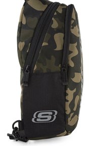 Mochila de camuflaje que presenta una tela texturizada, dos cremalleras en contraste y una base negra sólida con un detalle de logotipo.