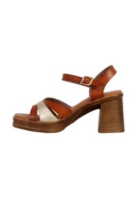 Braune Leder-Plateausandalen mit einem breiten metallischen Silberelement, hoher Blockabsatz und verstellbarem Knöchelriemen.