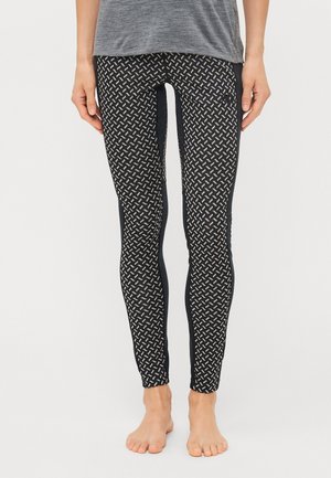 Sorte leggings med et geometrisk hvitt mønster, og med en ensfarget svart sidelapp. Laget av elastisk stoff. Flat midjebånddesign.