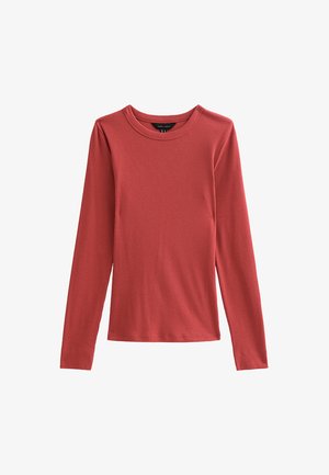 Camiseta de manga larga y cuello redondo en un color óxido sólido. Confeccionada en una tela suave con un diseño ajustado y textura acanalada.