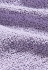 Tessuto di colore lavanda chiaro con un motivo tessuto e testurizzato. Il tessuto presenta una caduta ondulata e una superficie morbida e tattile.