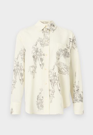 Cream button-up shirt with black floral line drawings, featuring a collar, long sleeves, and a chest pocket. Soft fabric texture.