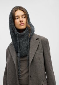 Knit grey wool hooded scarf with a soft, textured finish, paired with a grey blazer featuring a notched collar and a single button closure.