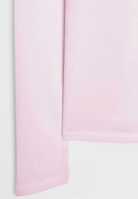 Rokav dolge majice svetlo roza barve z izrazito fino pleteno strukturo ter dvakrat šivanimi šivi na belem ozadju.