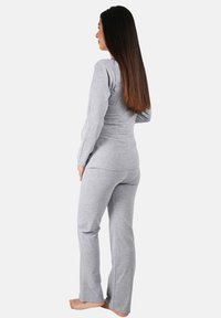 Graues Langarmoberteil und passende Hose aus weichem, leichtem Stoff. Figurbetontes Design mit glatter Textur, das eine entspannte Silhouette zeigt.