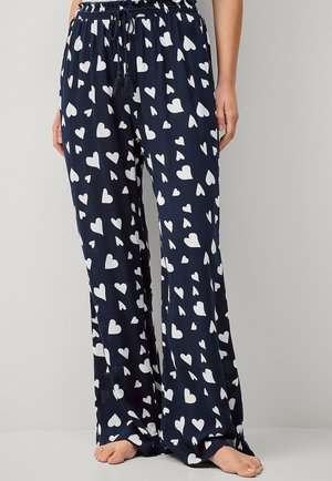 Marineblauwe broek met een witte hartpatroon, losse pasvorm, elastische tailleband met een trekkoord en zachte, lichte stof.