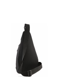 Sac bandoulière noir en matériau en maille texturée, présentant une forme triangulaire, une sangle réglable et une poche zippée sur le côté.