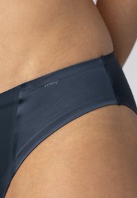 Slip bikini in blu navy con una texture liscia e rigata e un logo discreto; presenta un design a vita media e dettagli di cucitura pulita.