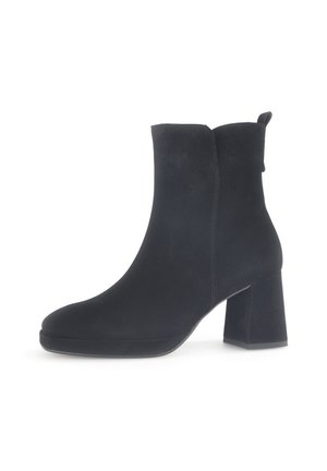 Bottine en suède noir à bout rond et talon carré. Elle présente une texture lisse et une languette à l'arrière pour un enfilage facile.