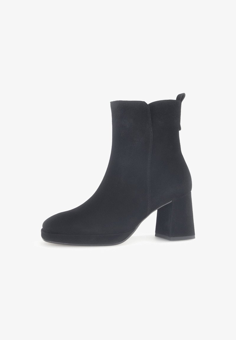 Schwarze Wildleder-Ankle Boots mit runder Schuhspitze und Blockabsatz. Sie verfügen über eine glatte Textur und eine Zuglasche auf der Rückseite für einfaches Anziehen.