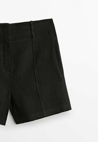 Shorts en lin noir avec une coupe classique, un devant plat et des poches latérales. Texture lisse et design ajusté pour un look épuré.