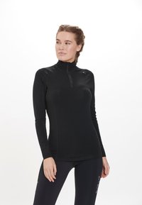Sort langærmet top med en halv-zip krave, lavet af strækbart stof. Har et tætsiddende design og kontrasterende syninger.