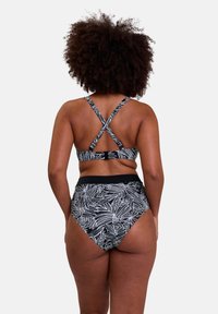 Ensemble de bikini noir et blanc avec des bretelles croisées et un bas taille haute avec un motif de feuilles de palmier. Texture lisse et ajustement réglable.
