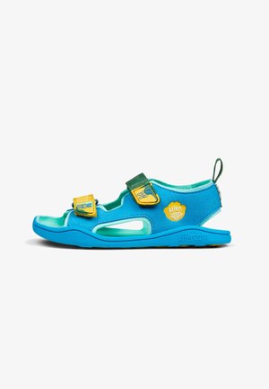 Sandales pour enfants bleu et vert avec sangles en velcro, design découpé, matériau doux, et un logo jaune sur le côté.
