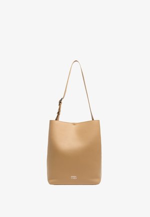 Sac fourre-tout en cuir tan avec une texture lisse, un design simple et une sangle d'épaule ajustable. Présente un logo subtil en bas.