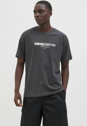 Graues Baumwoll-T-Shirt mit kurzen Ärmeln, mit weißen Textgrafiken "CORE90 CREATIVE STUDIO" auf der Vorderseite. Einfaches Design, lockere Passform.