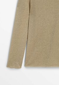 Pull en maille beige présentant une texture douce, des manches longues et une coupe décontractée. Le matériau est léger, respirant et tissé de manière uniforme.