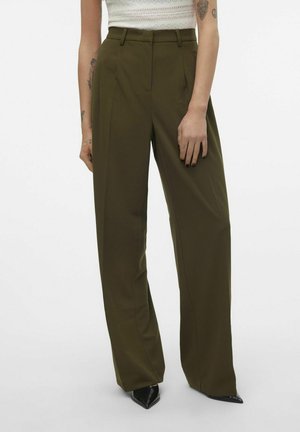 Olijf groene wijde broek met een hoge taille, voorzien van plooien en een gladde textuur. Gecombineerd met spitse zwarte schoenen.