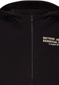 Zwarte rits-hoodie van zachte stof, met een capuchon en de tekst "RETROU JEANS ESSENTIAL IT STARTS WITH" in lichte kleur gedrukt.
