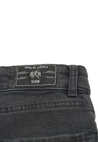 Svarta denimjeans med en texturerad yta, med en rektangulär etikett som visar "Band of Rascals" och "DENIM" i vit tryck.