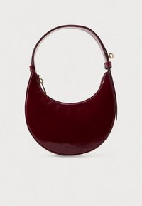 Rounded burgundy handbag in glossy leather, featuring a single thin shoulder strap and a gold-tone hardware accent. Smooth texture.