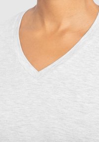Grå v-hals t-shirt lavet af et blødt, let stof med en subtil tekstur, og har et rent, klassisk kravedesign.