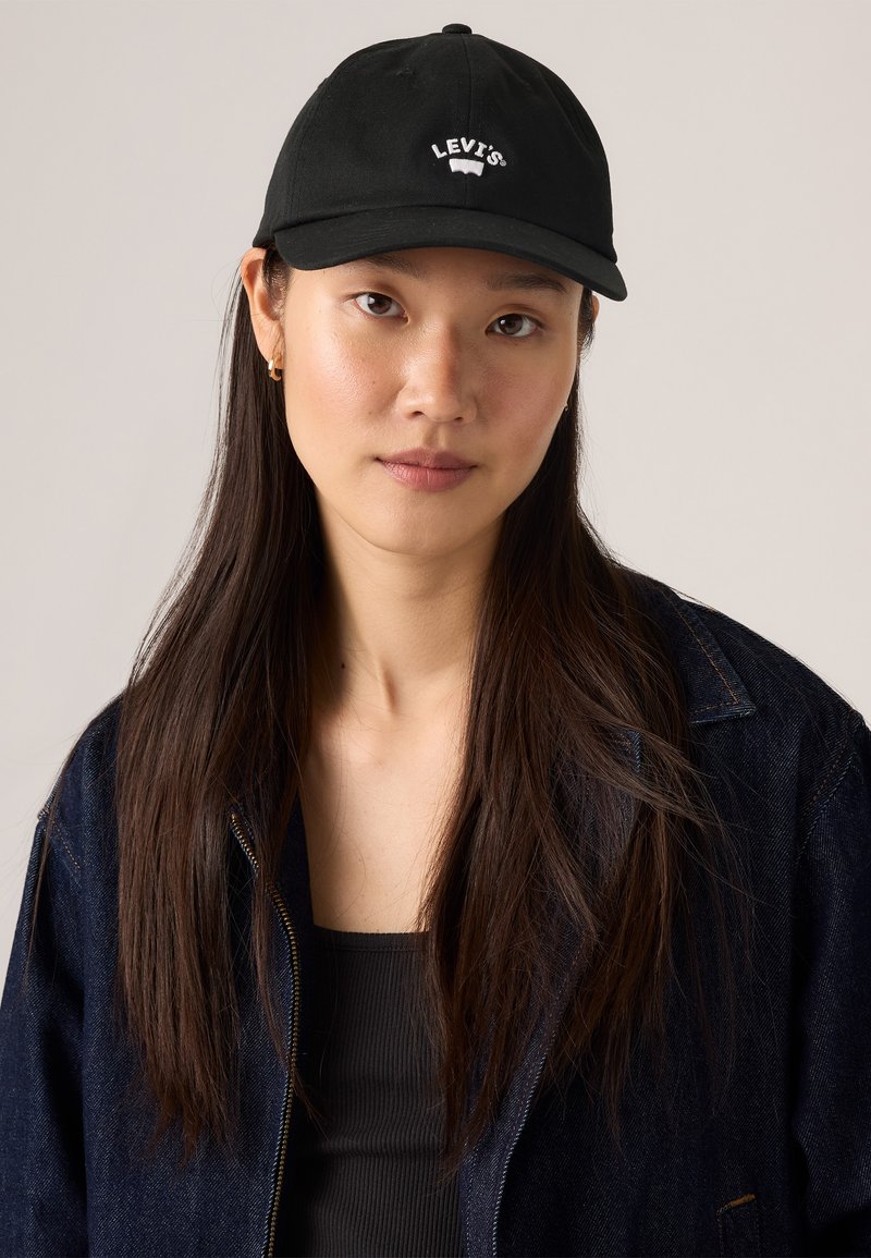 Casquette de baseball noire avec un logo Levi's brodé en blanc à l'avant, fabriquée en matériau textile, dotée d'une couronne structurée et d'un bord incurvé.