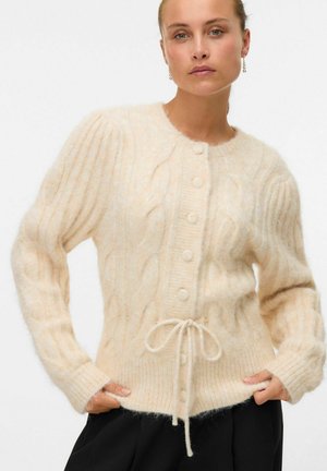 Gilet en tricot torsadé crème avec fermetures à boutons, poignets côtelés et cordon de serrage à la taille. Tissu doux et texturé avec une coupe décontractée.