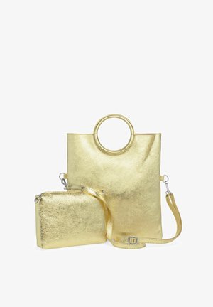Gold metallic tote bag with a circular handle and a detachable small pouch. Smooth texture, minimalistic design, and adjustable shoulder strap.