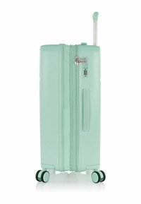 Valigia rigida verde menta con manico telescopico, ruote doppie e chiusura a zip. Dotata di serratura a combinazione e maniglia laterale.