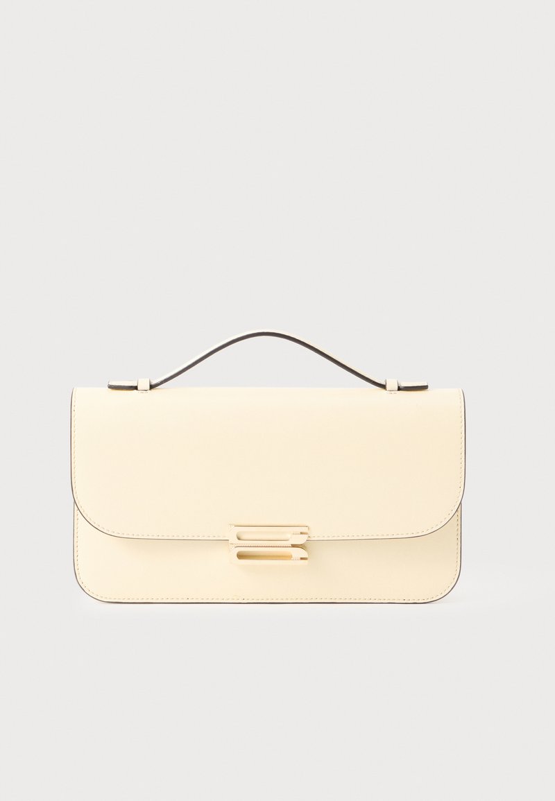 Kreemivärvi nahast käekotil on ülemine käepide ja kuldsetooniline ristkülikukujuline klamber, mis on paigutatud ühelevärvilisele heledale taustale.