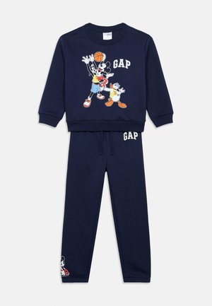Marineblauer Jogginganzug mit Sweatshirt im Crewneck-Stil, das mit Cartoonfiguren und dem "GAP"-Logo bedruckt ist, kombiniert mit passenden Jogginghosen mit Logoaufdruck.