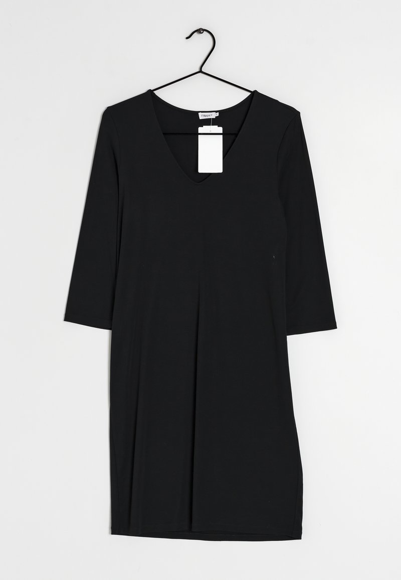 Mustahdussin musta V-pääntie mekko, jossa on kolmivartiset hihat ja väljä leikkaus. Tasainen ja sileä pinta, riippuu mustasta koukusta, johon on kiinnitetty valkoinen etiketti.